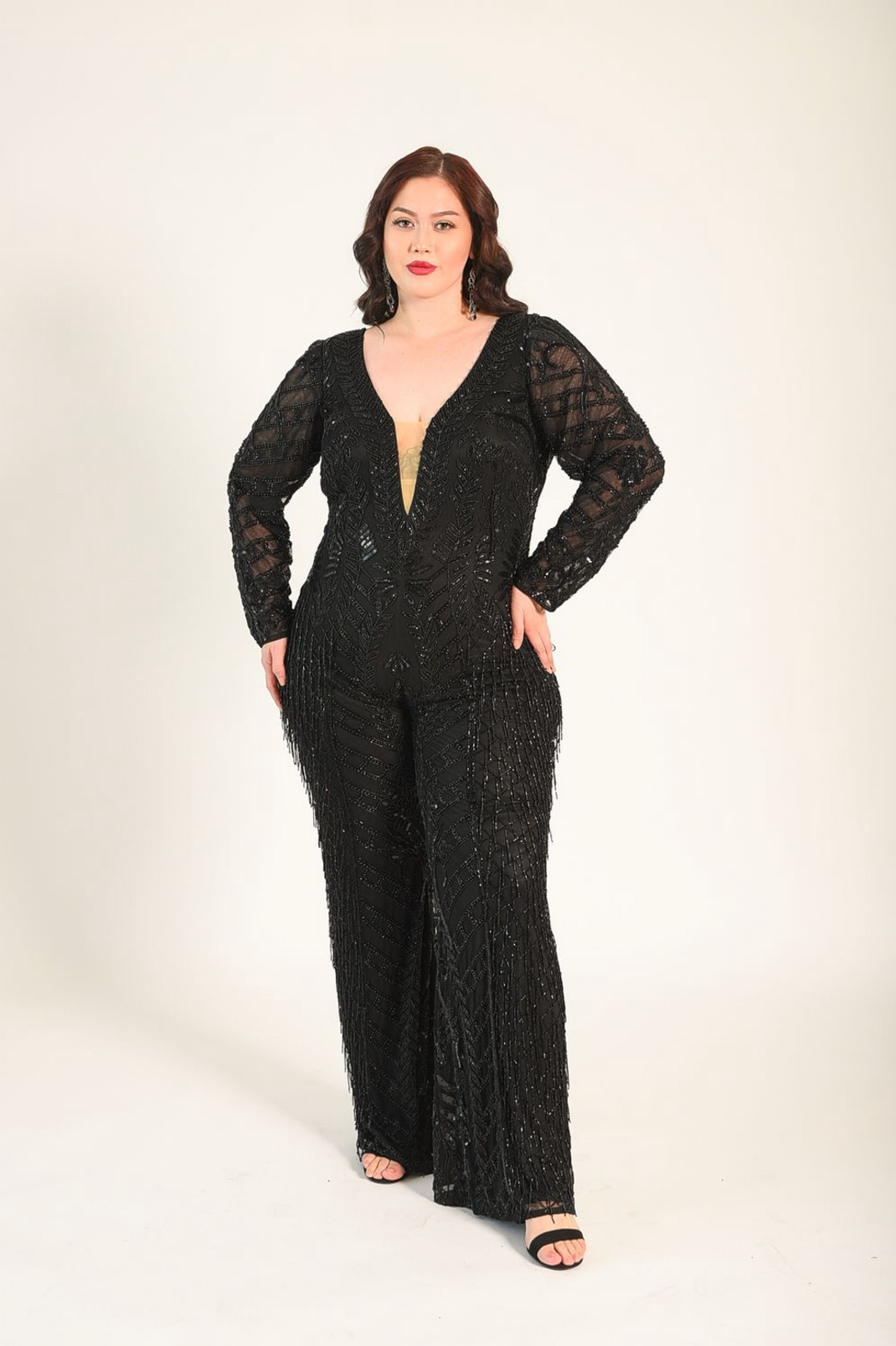 Beaded jumpsuit, with sheer sleeves. Sheer panel along the bust line. V-neckline. Back zipper. 