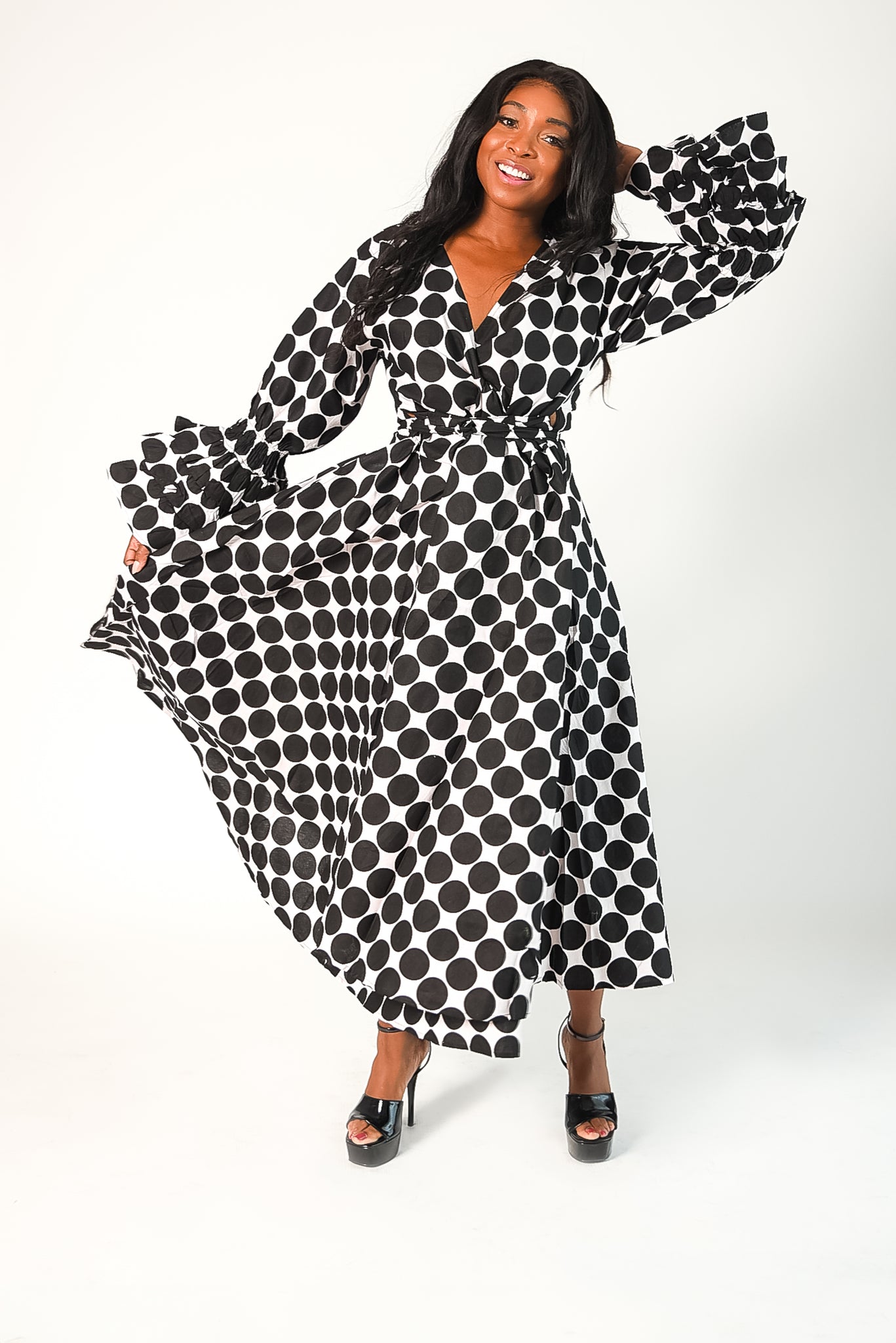 black and white polka dot wrap style dress with tiered ruffle sleeves. Dress has pockets. 