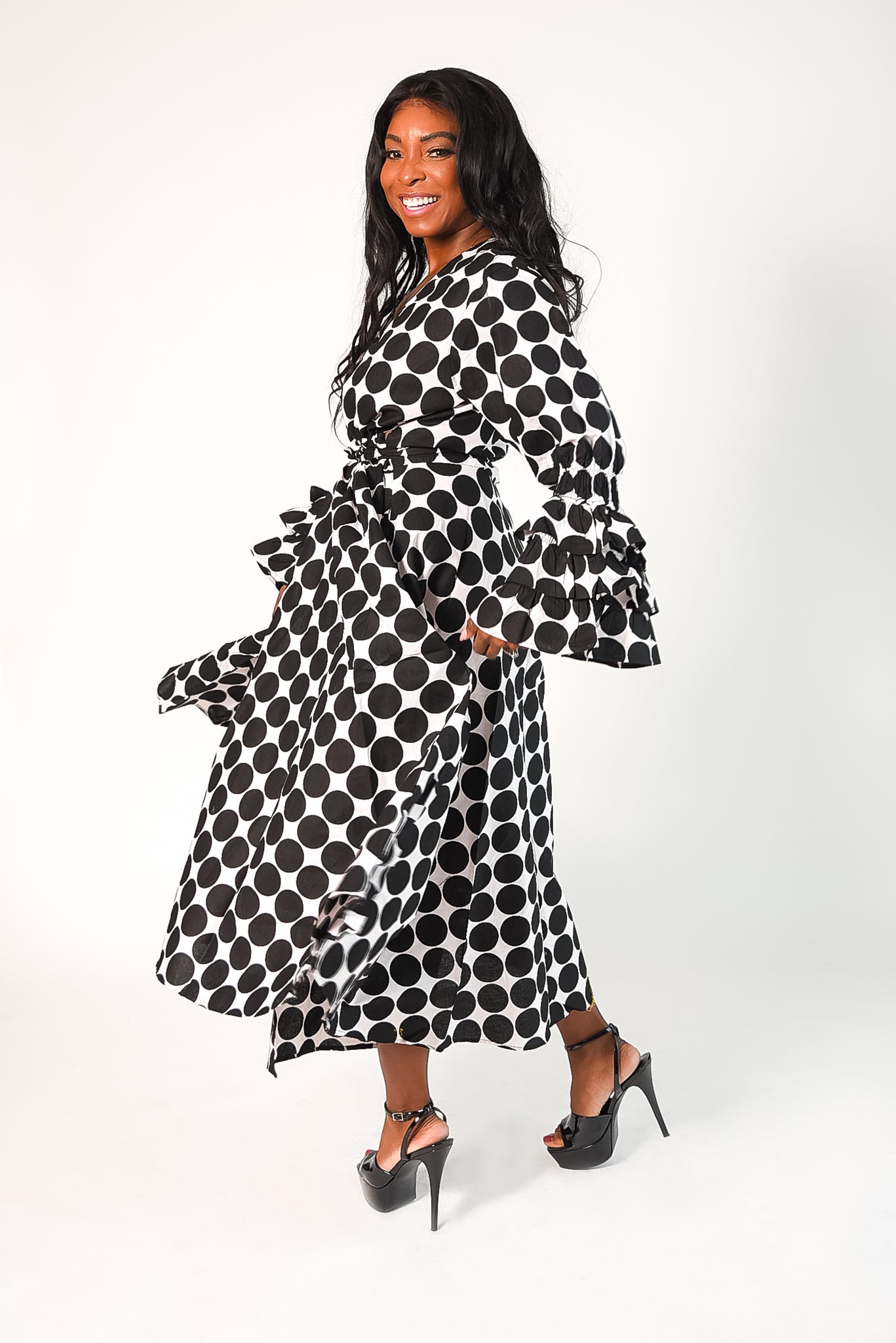 black and white polka dot wrap style dress with tiered ruffle sleeves. Dress has pockets. 