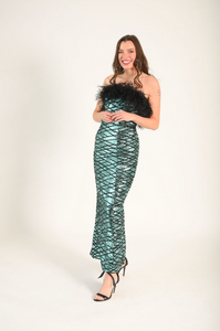 Blue/green sequin fabric with black zig-zag lines across each other. Black feathers adorn the bodice. The dress is strapless. 